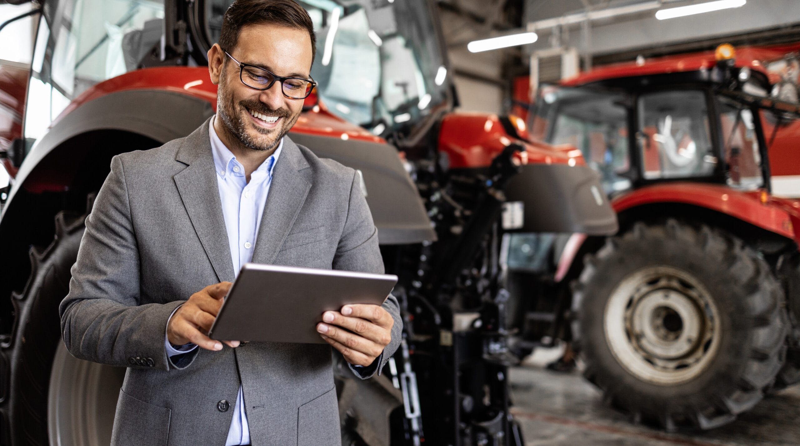 Vendedor consulta um tablet em uma concessionária de máquinas agrícolas