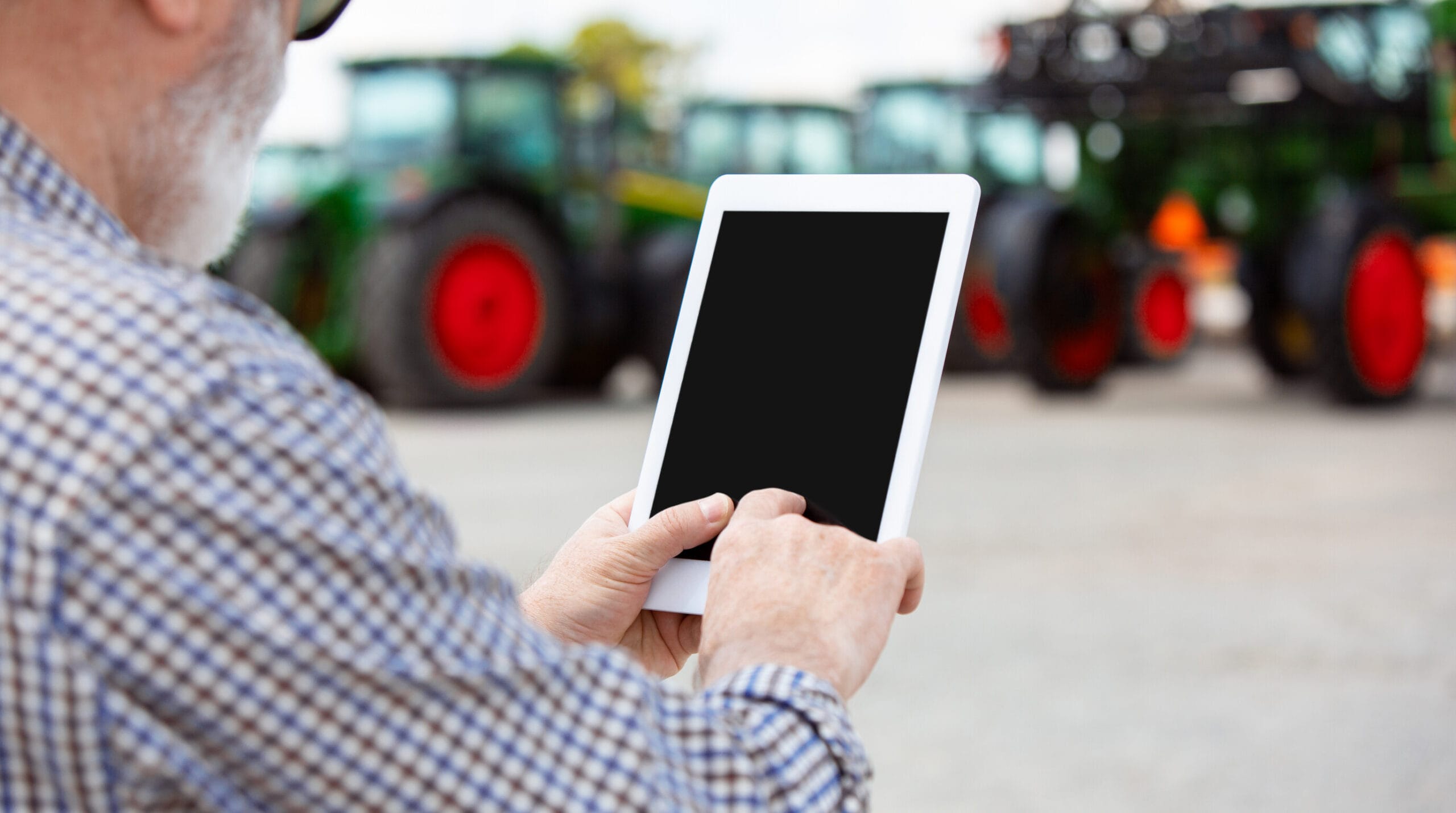 Profissional do agronegócio analisando informações de uma máquina agrícola em um tablet